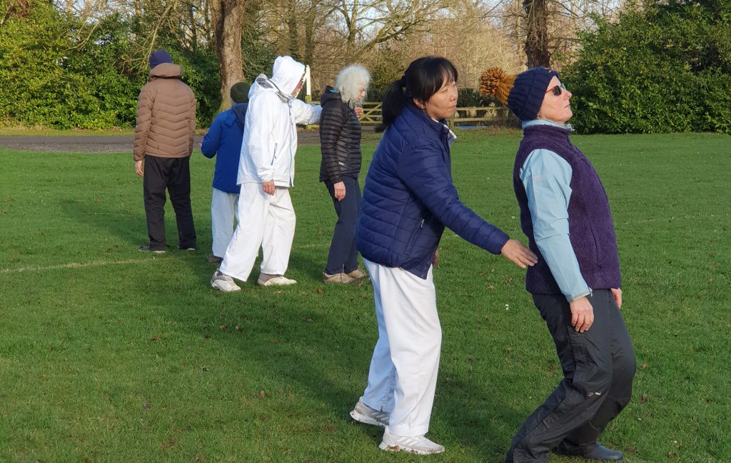 Group of people practicing seaweed exercise on a football pitch