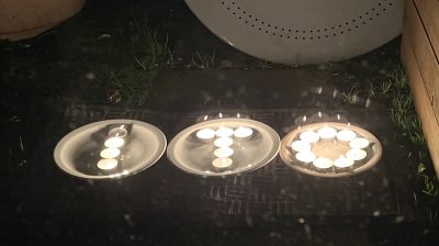 Three bowls with floating tea lights spelling I-T-O